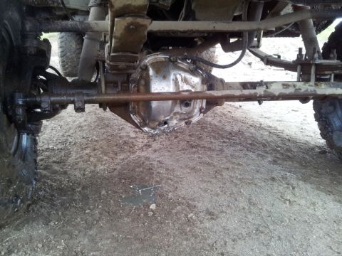 1990 Chevrolet Suburban - Close-up of a vehicle's rear differential and suspension system, showing signs of wear and damage.