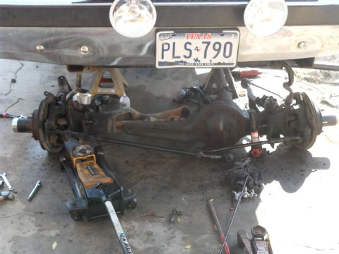 1990 Ford Bronco - The rear axle assembly of a vehicle is shown supported by jack stands and a floor jack.