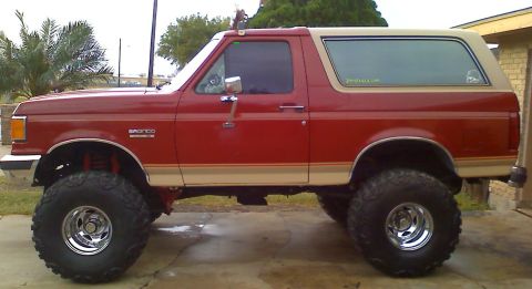 1990 Ford Bronco - This lifted Ford Bronco has large off-road tires and a two-tone paint scheme.