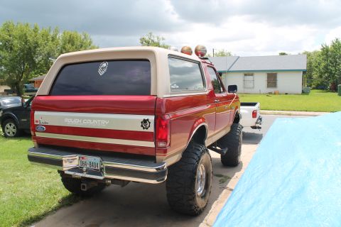 1990 Ford Bronco - This 1990 Ford Bronco features a lifted suspension and large off-road tires, with 'Rough Country' branding visible on the side.