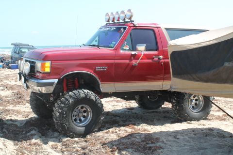 1990 Ford Bronco - This lifted Bronco is set up for camping on the beach with an attached tent.