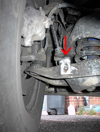1996 Ford Crown Victoria - A red arrow points to a suspension component in this close-up view of a vehicle's undercarriage.