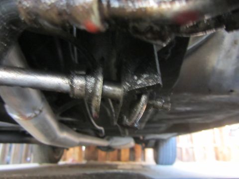 1964 Ford Ranchero - Close-up view of a vehicle's greasy undercarriage, focusing on the steering components and exhaust system.