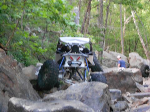 1967 Ford Mustang - A custom off-road buggy is seen traversing a challenging rocky path in a wooded area.