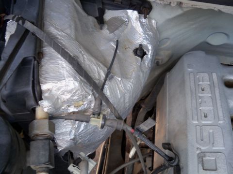 1995 Ford Bronco - Close-up view of the engine compartment of a 1995 Ford Bronco, showing the "Ford" branded valve cover and insulation.