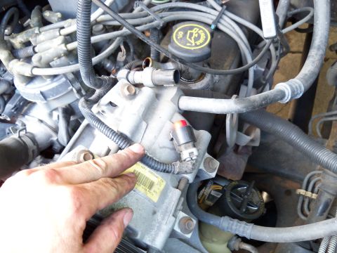 1995 Ford Bronco - This image shows the engine bay of a vehicle after the air conditioning system has been removed.