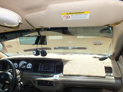 2003 Ford Crown Victoria - Cabin view of a tan Crown Victoria, airbag warning visor down over the windshield.