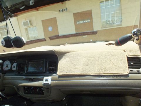2003 Ford Crown Victoria - Tan Crown Victoria dashboard with P-Type Police Package badging, shop building outside.
