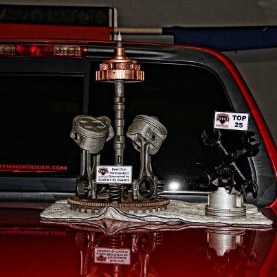 2007 Ford Mustang - A custom trophy crafted from engine components is displayed on the back window of a vehicle.