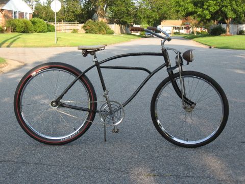 1994 Ford Bronco - A custom black bicycle with wide tires and a vintage headlight sits on a suburban street.