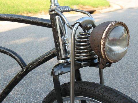 1994 Ford Bronco - Close-up of a vintage bicycle's front end, a rusty headlight and chrome suspension.