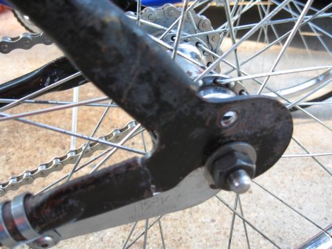 1994 Ford Bronco - Detail of a bicycle's rear wheel assembly, showing the chain and spokes with visible markings on a metal component.