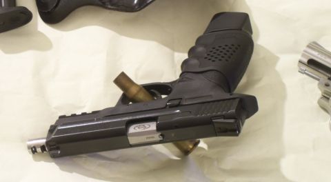 2000 Mercury Grand Marquis - A black pistol with a bullet casing is shown, with a portion of a revolver visible to the right.