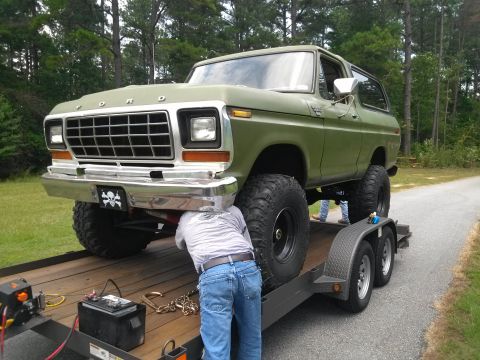 1979 Ford Bronco - A green 1979 Ford Bronco is being worked on while loaded onto a trailer.