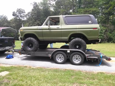 1979 Ford Bronco - This lifted Ford Bronco is being transported on a trailer, showing its off-road modifications.