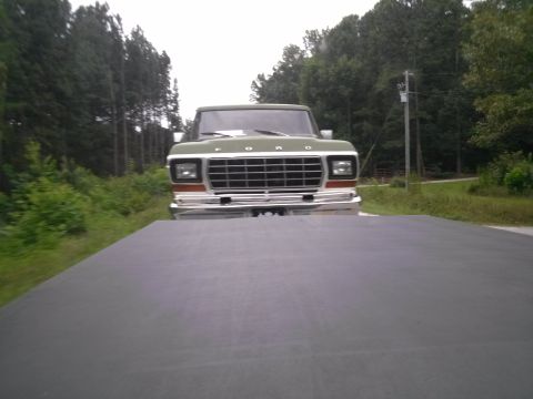 1979 Ford Bronco - Green 1979 Ford F-Series truck seen from a low angle, showing its front grille and headlights.