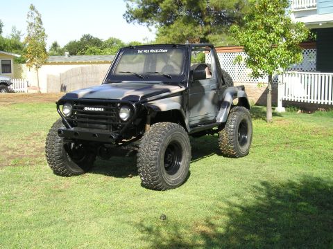 1987 Suzuki Samurai - This 1987 Suzuki Samurai features camouflage paint and oversized tires, suggesting off-road modifications.