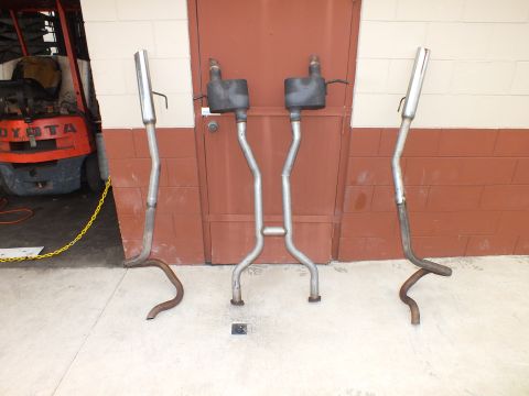 2003 Ford Crown Victoria - Complete dual exhaust assembly stood up against a shop door for display.