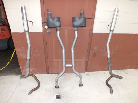 2003 Ford Crown Victoria - Dual exhaust with twin mufflers and curved tailpipes arranged against masonry.