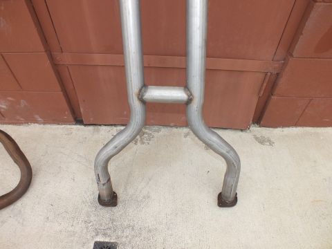 2003 Ford Crown Victoria - Detail of an exhaust crossover joining two pipes near rusted hanger ends.