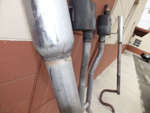 2003 Ford Crown Victoria - Detail of a polished exhaust tip welded to pipe, marked 05, other pipes behind.