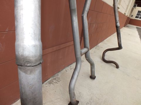 2003 Ford Crown Victoria - Welded aluminized exhaust pipe shown close up, curved tailpipes in background.