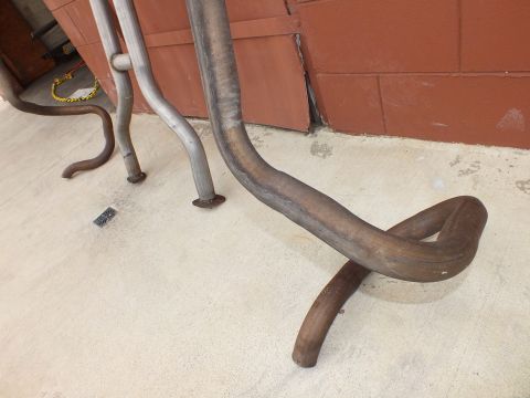 2003 Ford Crown Victoria - Rust-toned exhaust pipe bent into an over-axle loop, raw pipes alongside.