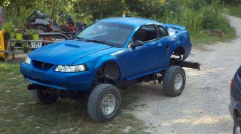 2007 Ford Mustang - A blue Ford Mustang has been modified with a lifted suspension and large off-road tires.