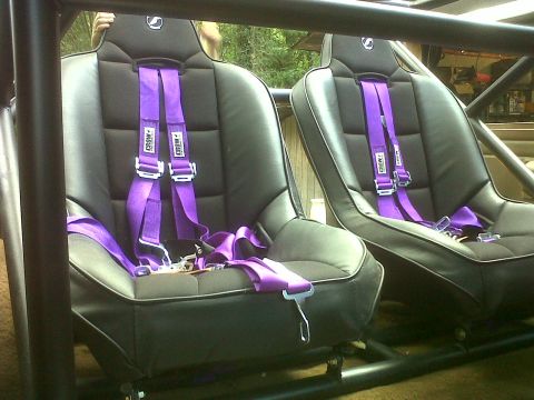 1990 Ford Bronco - Interior view of two racing seats with purple harnesses, part of a custom build.