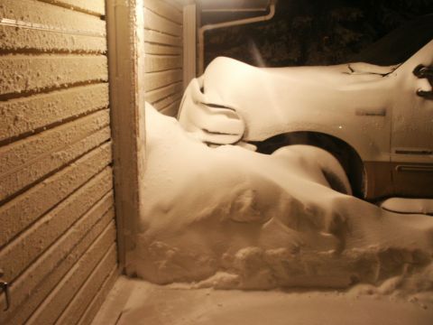 2000 Ford F-250 - Truck buried in snow drifts next to a building wall.