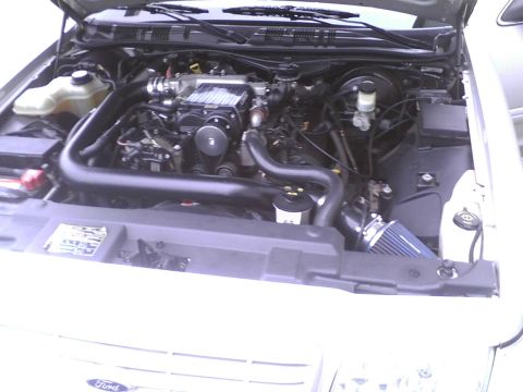 2003 Ford Crown Victoria - Engine bay of a 2003 Ford Crown Victoria, a supercharger and blue cone air filter.