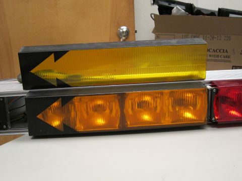 1991 Ford LTD Crown Victoria - Close-up of a light bar with amber and red lenses, directional arrow graphics on the housing.