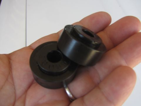1964 Ford Ranchero - Two black cylindrical parts, possibly for steering, are held in a hand.