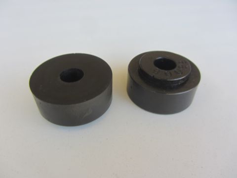 1964 Ford Ranchero - Close-up of two black rubber bushings, one showing stamped numbers.