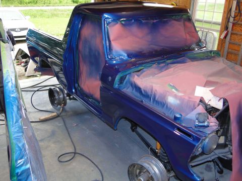 1978 Ford Bronco - A blue Ford pickup truck is being prepped for a new paint job in a garage.