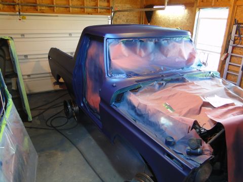 1978 Ford Bronco - A pickup truck is being prepped for a new paint job in a garage, with protective coverings on the hood and doors.