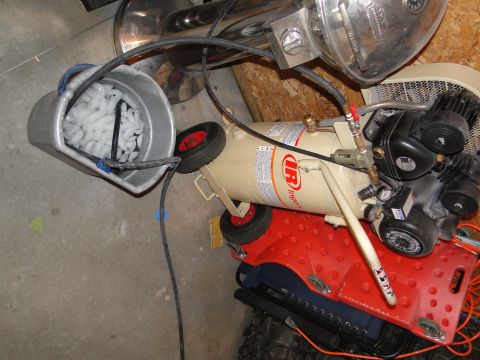 1978 Ford Bronco - Air compressor setup with a bucket filled with ice and connected hoses.