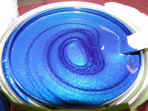 1978 Ford Bronco - A can of metallic blue paint is being stirred, showing swirling patterns and glittery texture.