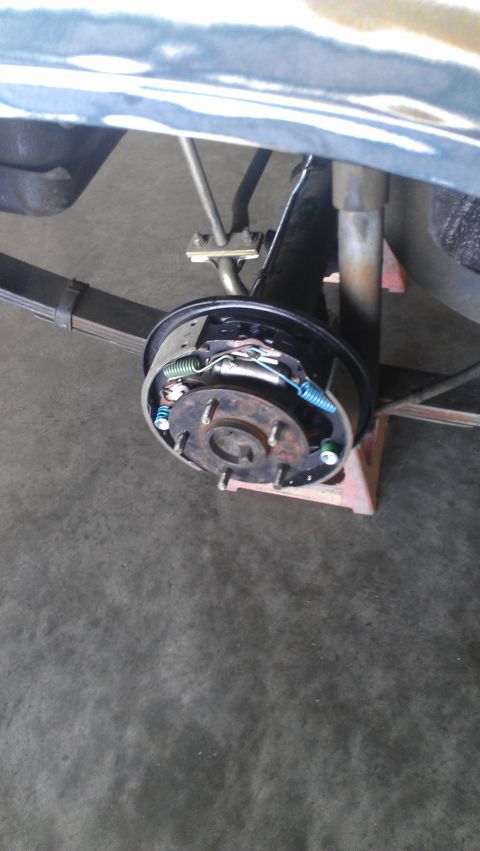 1973 Chevrolet Camaro - The rear drum brake assembly of a vehicle is shown, supported by jack stands.