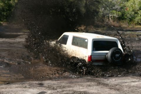1988 Ford Bronco - 1988 Ford Bronco navigating a challenging muddy terrain.
