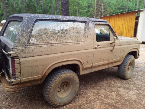 2012 Ford Bronco - This SUV is covered in mud, obscuring its exact make and model year.