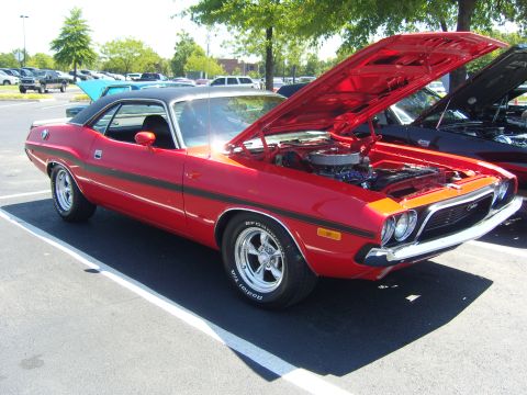 2007 Ford Mustang - A red Dodge Challenger is parked with its hood open, revealing the engine bay.