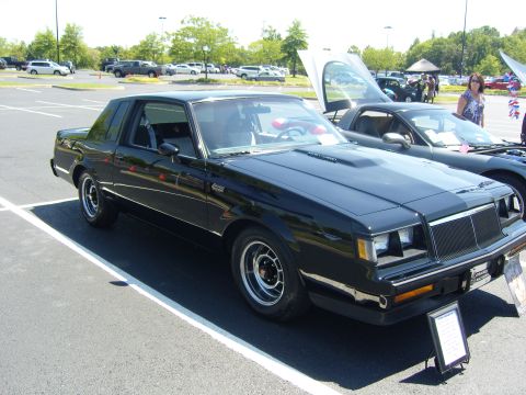 2007 Ford Mustang - A black coupe with a distinctive grille and hood scoop is displayed at an outdoor event.