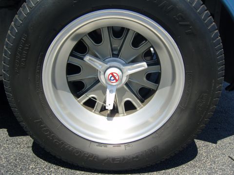 2007 Ford Mustang - A close-up view of a vintage-style car wheel and tire, a distinctive spinner cap.