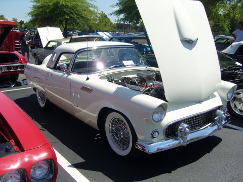 2007 Ford Mustang - A classic white Ford Thunderbird is displayed with its hood open at an outdoor car show.