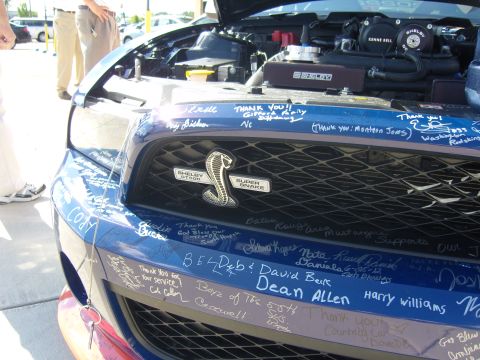 2007 Ford Mustang - A blue 2007 Ford Mustang Shelby GT500 Super Snake is covered in signatures on its front end.
