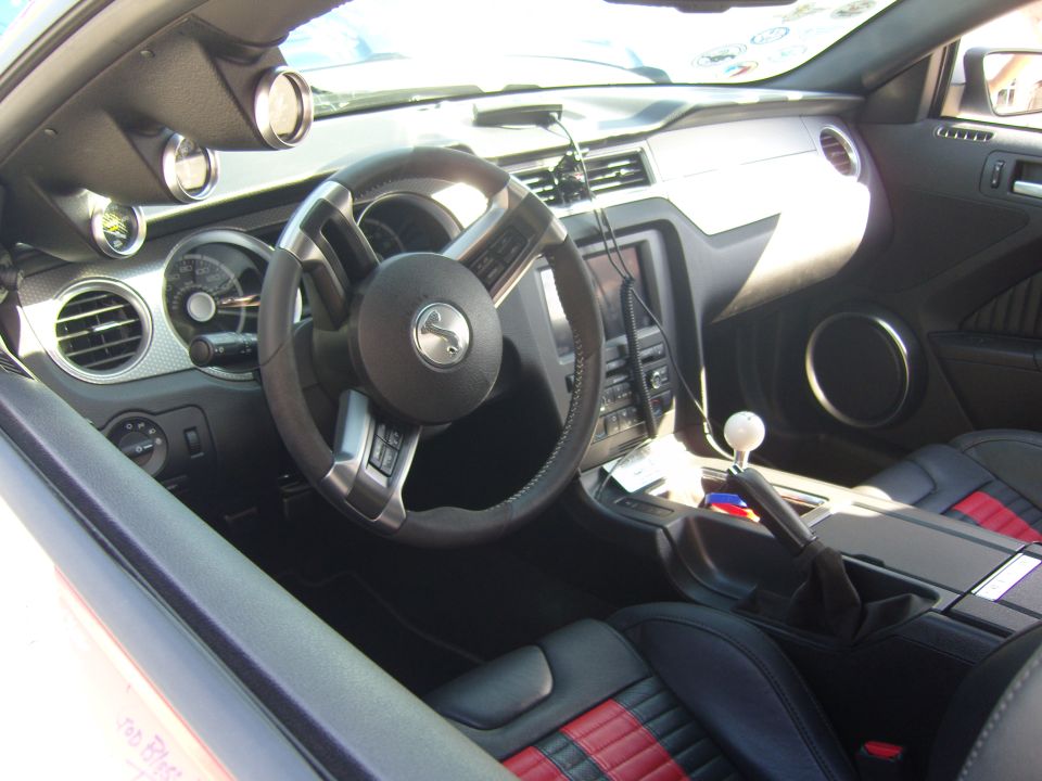Interior view of car with racing seats, aftermarket gauges, and manual shifter