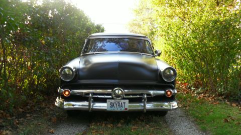 1954 Ford Crestline - Front view of a 1954 Ford Crestline sedan with a matte black finish, parked outdoors.