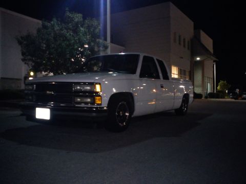 1997 Chevrolet Silverado 1500 - A white 1997 Chevrolet Silverado 1500 pickup truck is parked at night in front of a building.