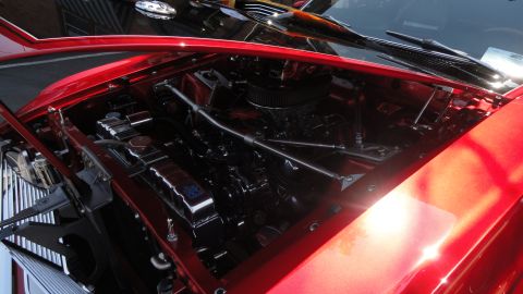 1964 Ford Fairlane - The engine bay of a red 1964 Ford Fairlane shows a V8 engine with chrome detailing.